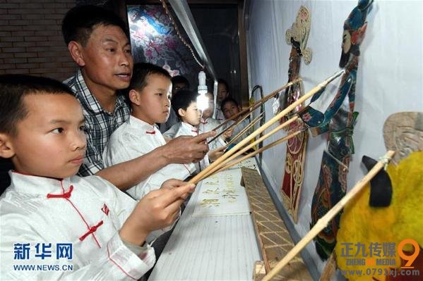 4月19日，萍乡市湘东区东桥镇界头村农民、湘东皮影戏第七代传人丁永发（左二）与界头小学学生一起演皮影戏。近年来，江西省非物质文化遗产、萍乡市湘东皮影戏在传承中创新，当地皮影戏剧团每年走村串巷下乡演出近200场，并让皮影戏走进学校，在小学生中普及这门传统艺术，深受百姓喜爱。新华社记者 宋振平 摄